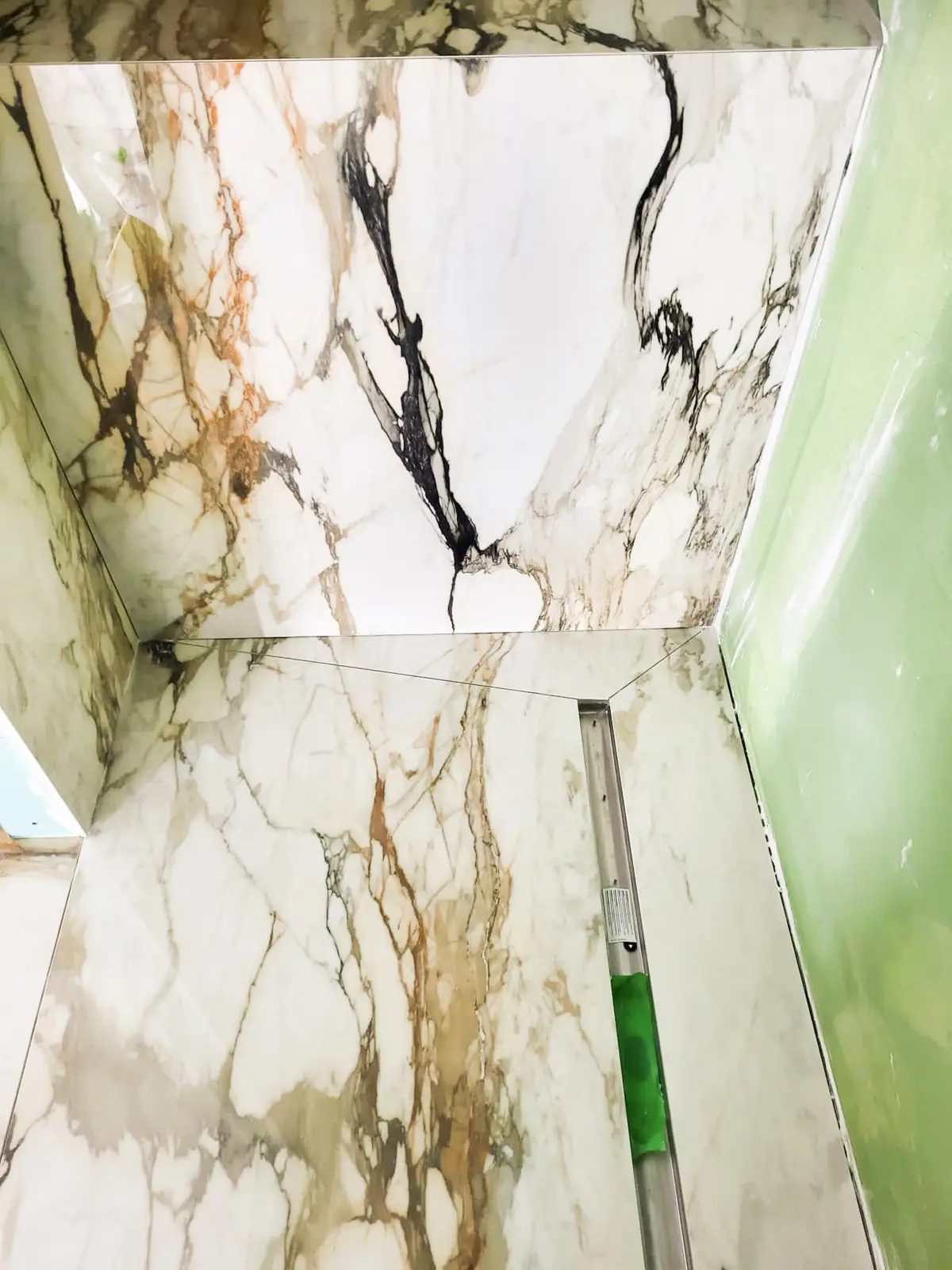 Douche habillée de grandes plaques effet marbre calacatta