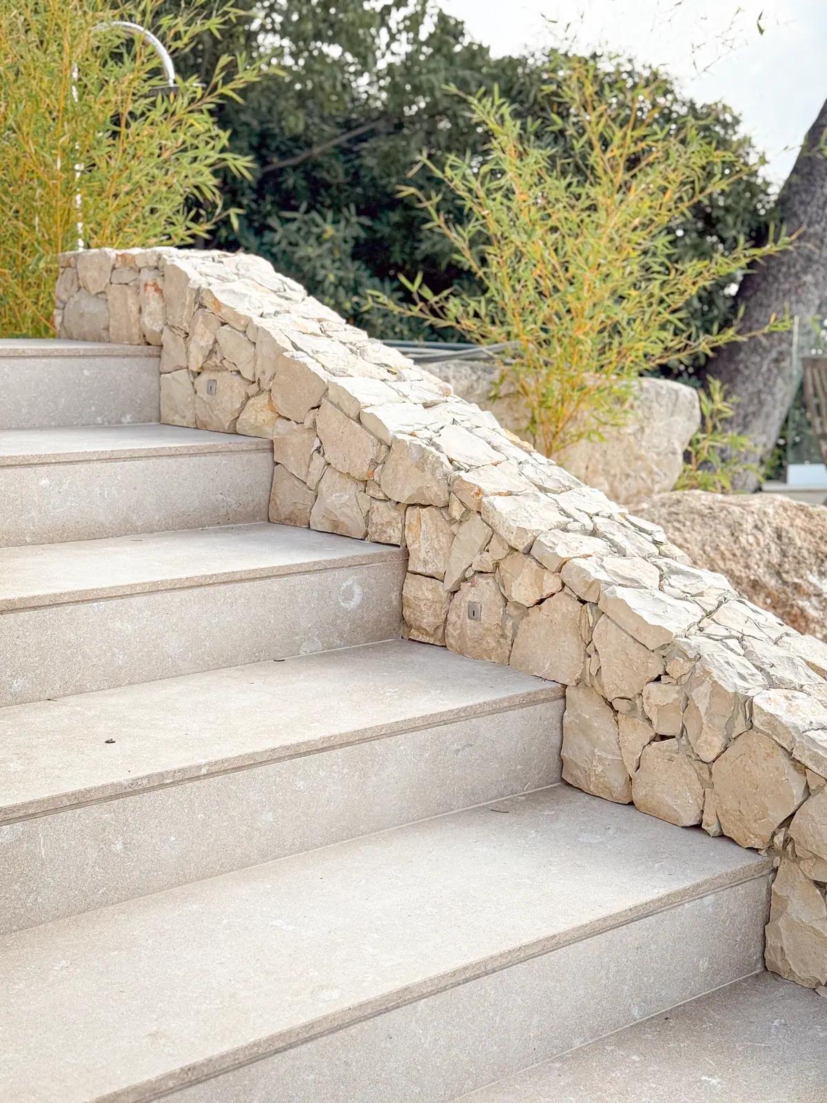 Escalier extérieur dallé et mur en pierre sèche