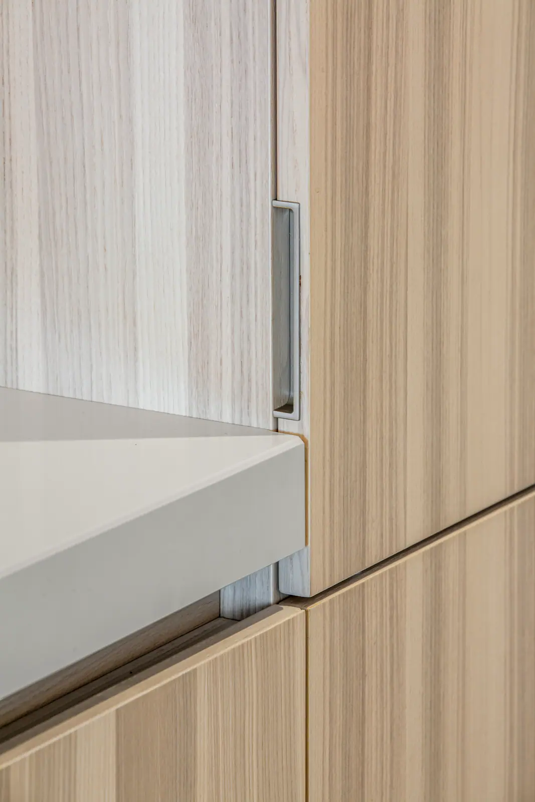 Détail d'un meuble en bois clair et d'un plan blanc