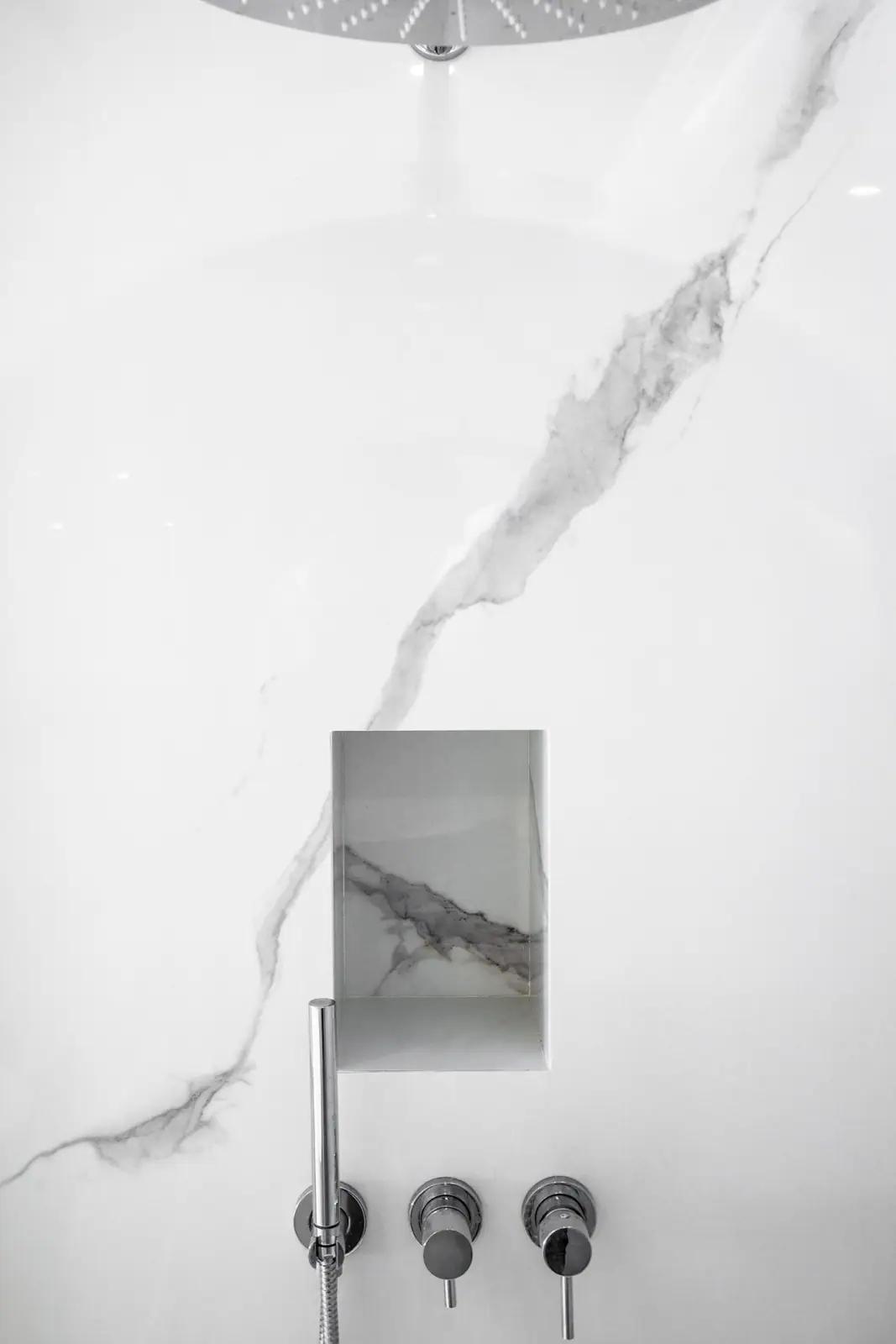 Robinetterie encastrée sur une grande plaque effet marbre blanc