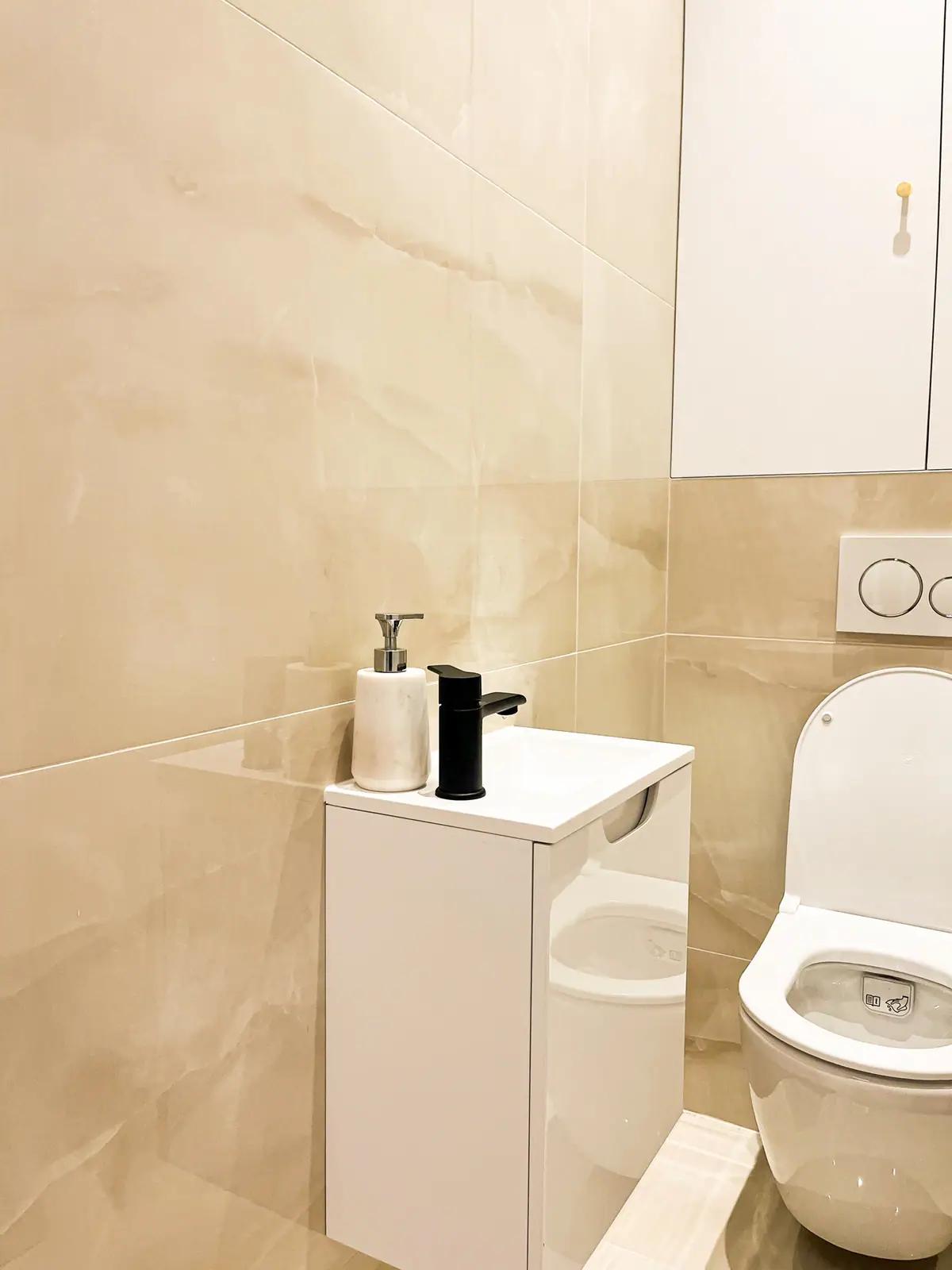 Sanitaires en carrelage clair et meuble suspendu