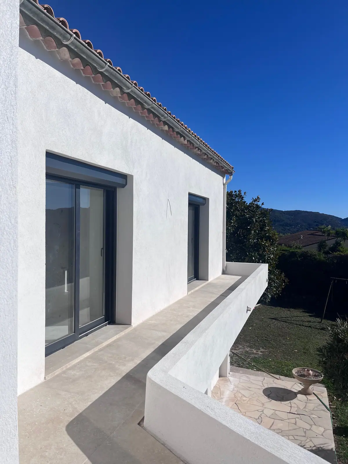 Façade blanche et terrasse de la maison