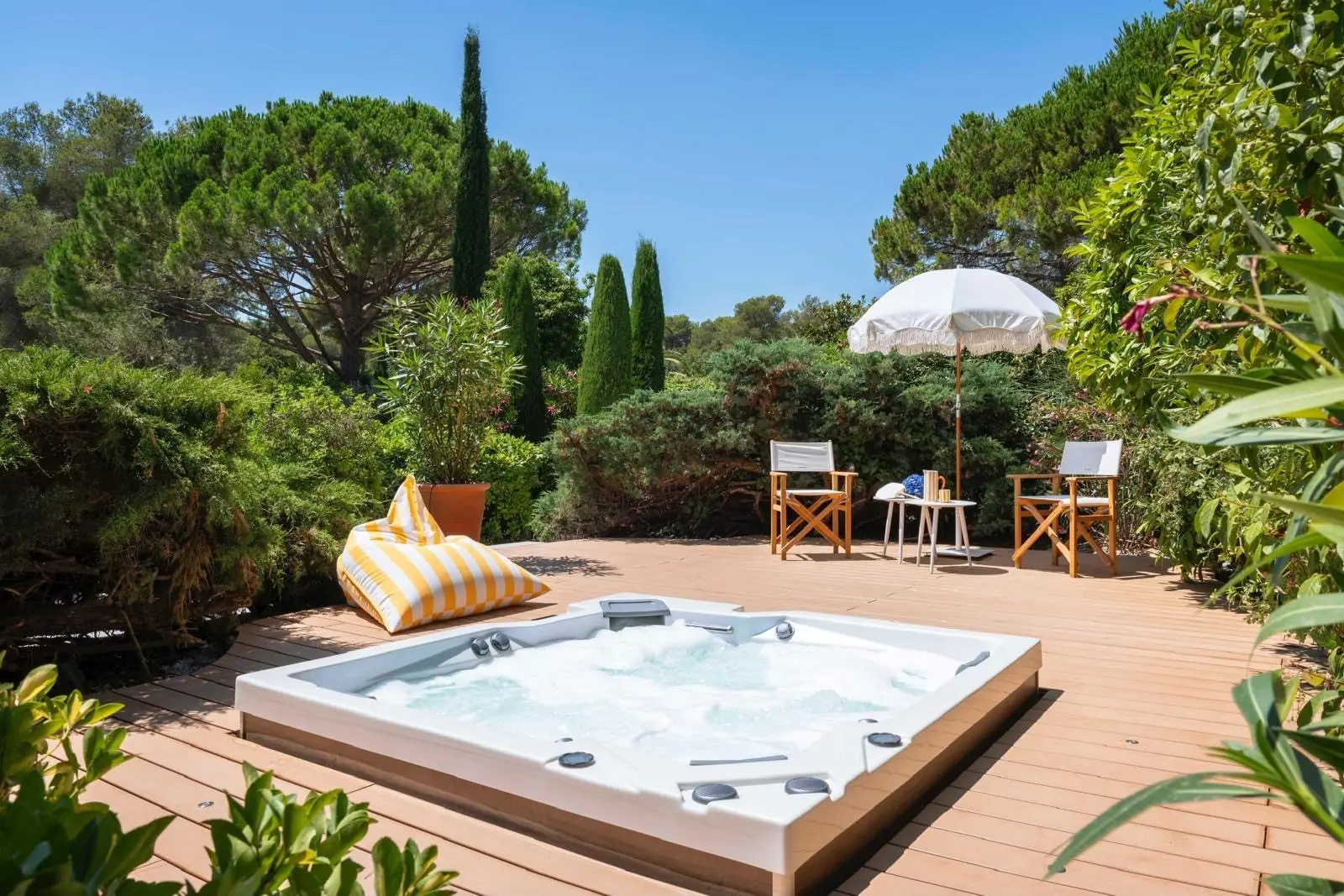 Terrasse en bois avec jacuzzi encastré dans un jardin méditerranéen